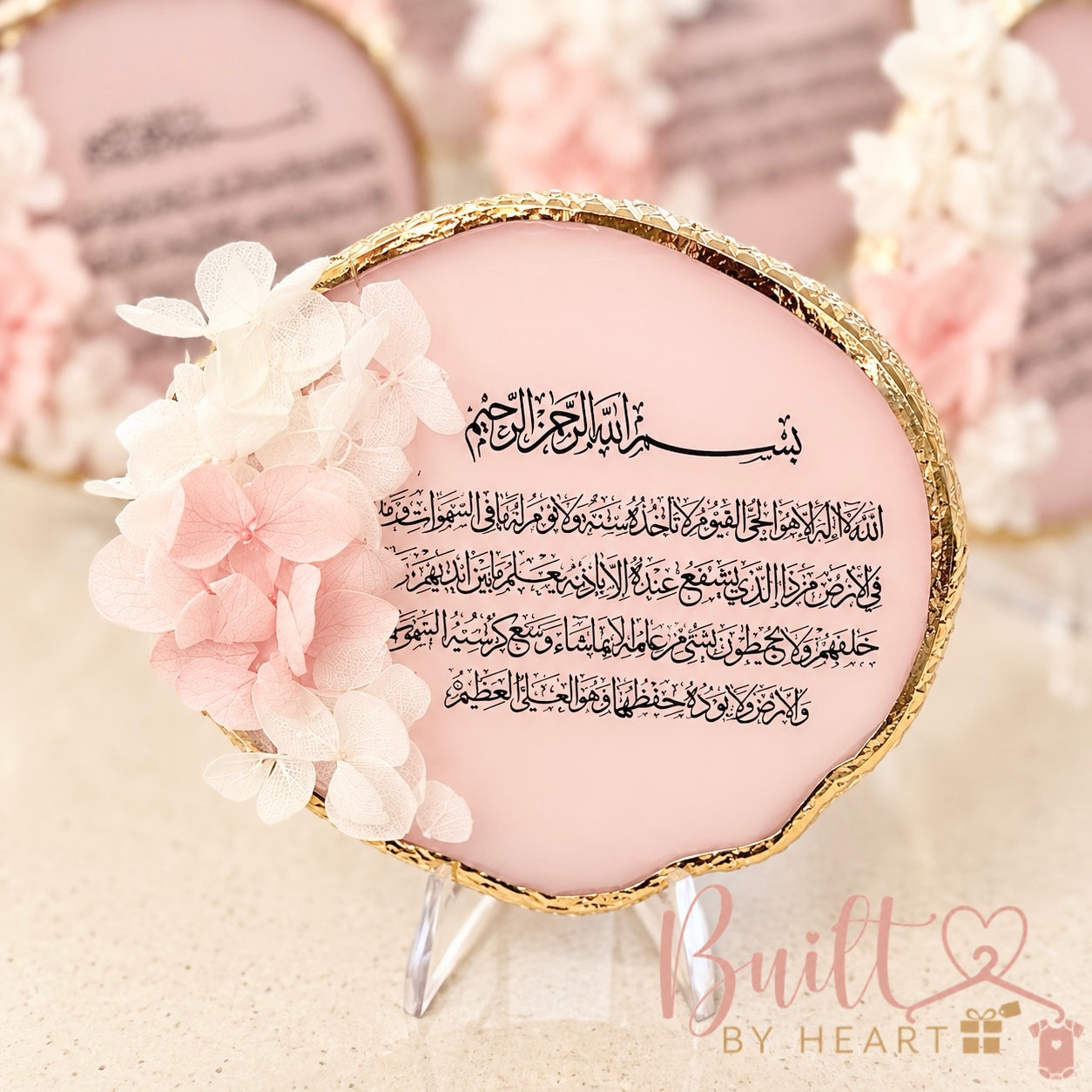 Pink and gold floral Quranic verse plaque with Arabic calligraphy